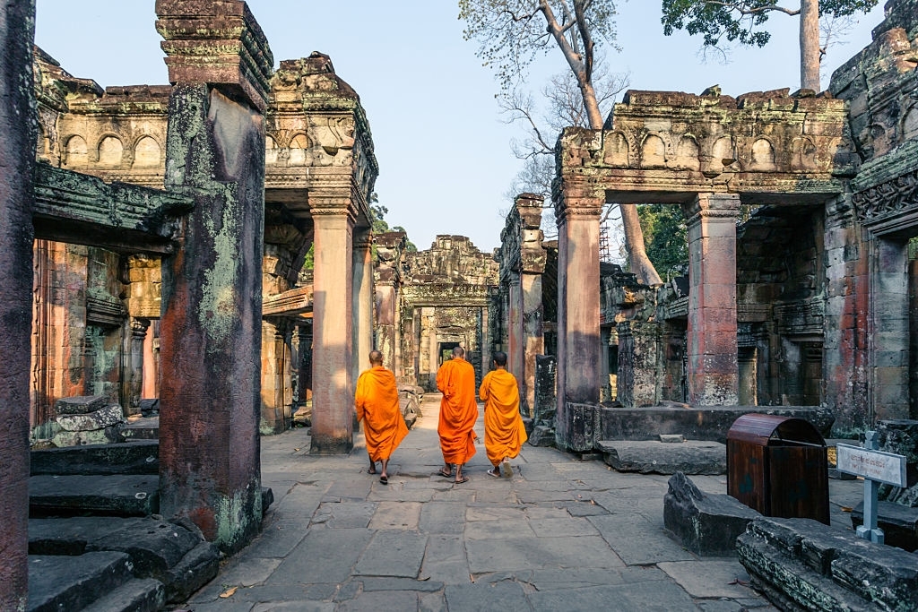 three-buddhist-monks-walking-inside-angkor-wat-temple-siem-reap-cambodia