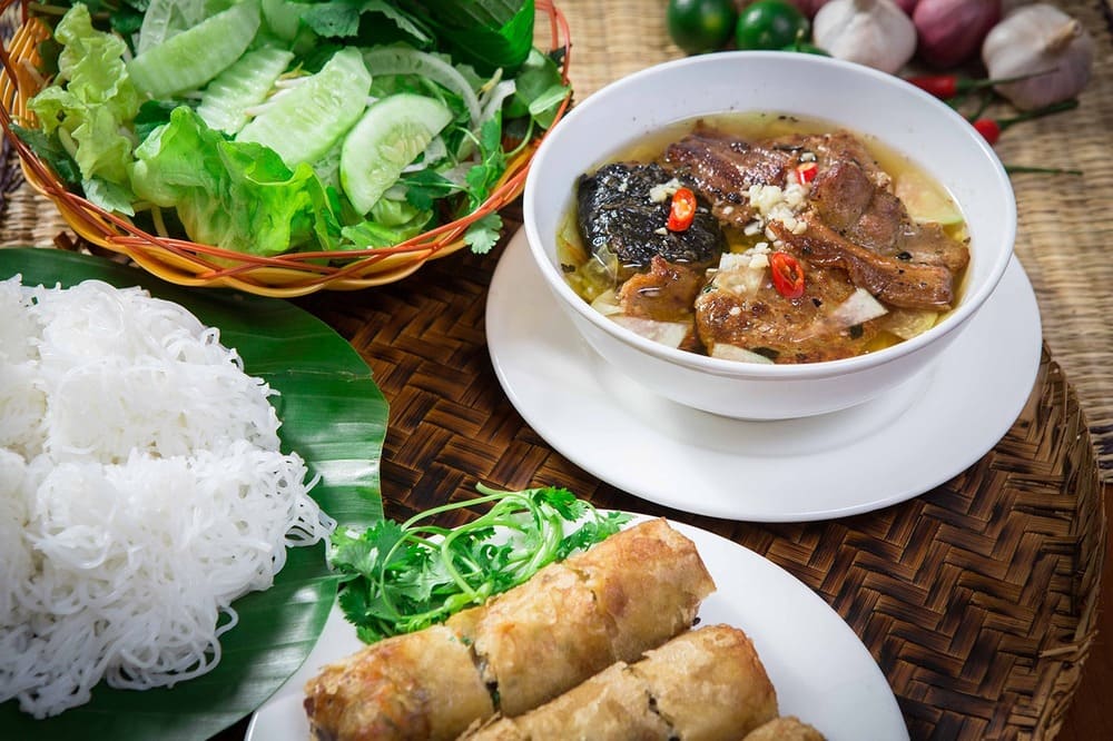 Bun cha de Hanoï avec porc grillé, vermicelles de riz, herbes fraîches et nems frits