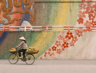 Une vendeuse de fruits à vélo devant la Route de la Céramique à Hanoï