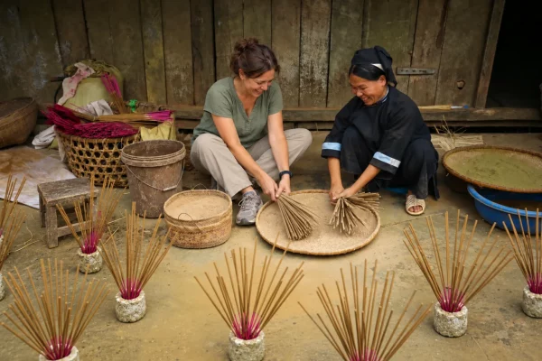 Une voyageuse s’initie à la fabrication de l’encens aux côtés d’une artisane de Phia Thap.