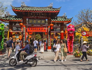 Ambiance animée devant la salle d’assemblée de Trieu Chau à Hoi An, entre visiteurs, lanternes et décorations traditionnelles.